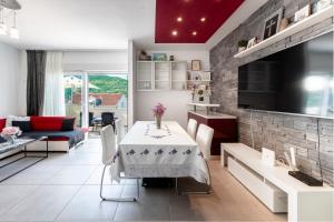 a living room with a table and a tv at Villa Lucia in Mokošica