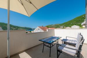 a patio with a table and a chair on a balcony at Villa Lucia in Mokošica
