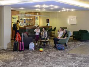 a group of people sitting in a lobby with luggage at Novotel Bayeux in Bayeux +79 photos