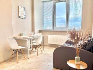 a living room with a couch and a table and chairs at Sea garden apartment in Kryzhanivka