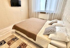 a small bedroom with a bed and a television at Sea garden apartment in Kryzhanivka