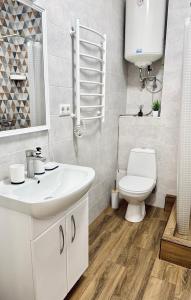 a bathroom with a white sink and a toilet at Sea garden apartment in Kryzhanivka +20 photos