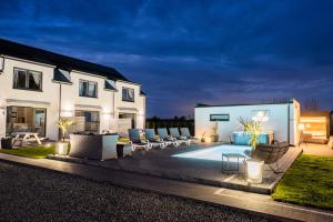a backyard with a pool and chairs and a house at Cichy Domek Karwia - Apartamenty - Basen, Jacuzzi, Sauna in Karwia