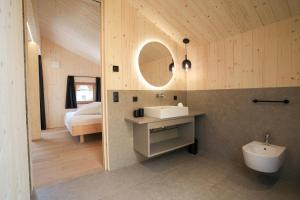 a bathroom with a sink and a mirror and a bed at Preindlerhof Farmloft in Valle Di Casies +35 photos