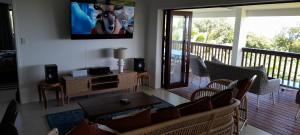 a living room with a couch and a tv on a balcony at Reureu Ocean Vistas in Arutanga