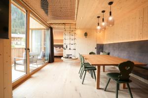 a dining room with a wooden table and chairs at Preindlerhof Farmloft in Valle Di Casies