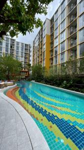 a swimming pool in front of a large building at The Rock Condo Central Phuket "Min-1 week" in Ban Rangeng