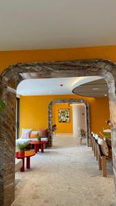 a living room with orange walls and a stone archway at The Rock Condo Central Phuket "Min-1 week" in Ban Rangeng