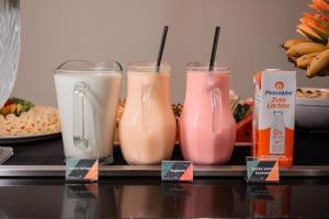 a group of four drinks in plastic cups on a counter at Hotel Sagres Praia in Balneário Camboriú