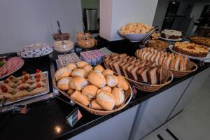a buffet with many different types of bread and pastries at Hotel Sagres Praia in Balneário Camboriú