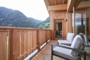 a balcony with chairs and a view of mountains at Preindlerhof Farmloft in Valle Di Casies
