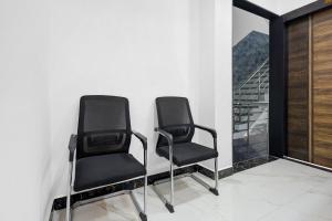 two black chairs in a room with a window at Super Hotel O Antilia in Gorakhpur