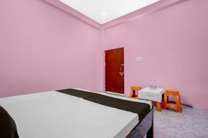 a bedroom with a bed and a table and two chairs at Hotel O A2Z Hotel in Lucknow