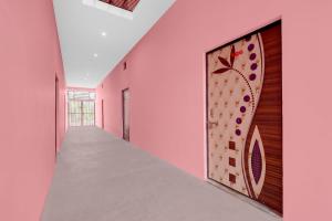 a hallway with pink walls and a painting on the wall at Hotel O A2Z Hotel in Lucknow