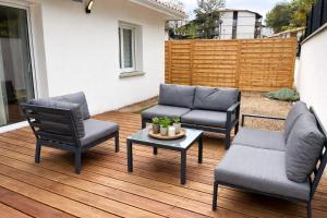 a patio with two chairs and a table and a couch at Charmante maison neuve proche Ocean in Léon