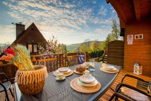 a table with plates of food on a balcony at Domki nad Zaporą w centrum Soliny przy Zaporze - wybrane domki z jacuzzi in Solina