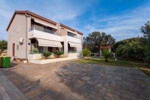 a large white house with a driveway in front of it at Apartments Melody in Mandre