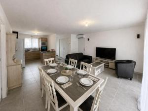a kitchen and living room with a table and chairs at Charmante maison neuve proche Ocean in Léon