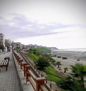 a row of wooden benches next to the beach at Sunset In Malabrigo in Puerto Chicama