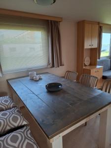a dining room table with a bowl on it at Stacaravan met schitterend uitzicht over het meer, in Friesland! Op de 5-sterren Camping de Kuilart met Zwembad! in Koudum