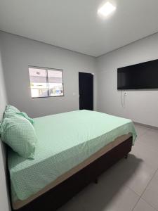 a bedroom with a bed and a flat screen tv at Lotus in Gurupi