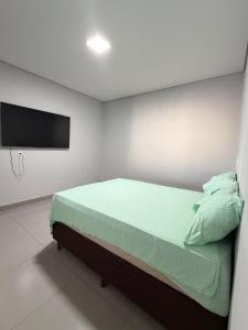 a bedroom with a bed and a flat screen tv at Lotus in Gurupi