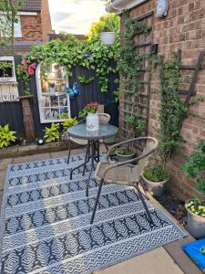a patio with a table and chairs on a rug at Nett'Als Lodge Studio Apartment in Derby +9 photos