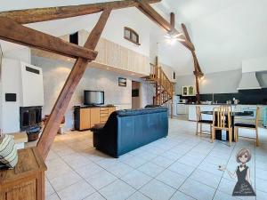 a large kitchen and living room with wooden beams at Le Gite Cazette in Ance