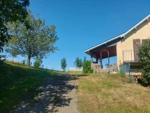 a house on a hill with a dirt road next to it at Le Gite Cazette in Ance