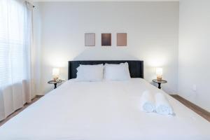 a bedroom with a large white bed with two lamps at Warm, Inviting 2BD Apt In Matthews in Charlotte