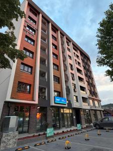 a tall building with a parking lot in front of it at Tilia Lux Wellnes &Spa in Čačak