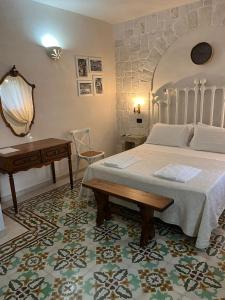 a bedroom with a bed and a table and a desk at Masseria Tolla in Ostuni