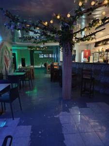 a restaurant with tables and a tree in the middle at Hostal Cigarra in Panama City