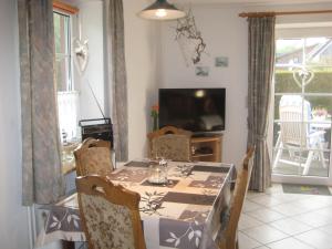 a dining room with a table and chairs and a television at Haus Bärbel in Barlt