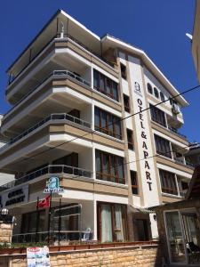 a tall white building with a sign on it at Alpaylar Otel & Apart in Akçay