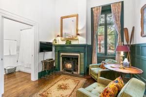 a living room with a green fireplace and a couch at Spacious Studio on Historic Inn Property in Asheville