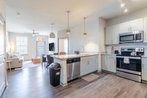 a large kitchen with white cabinets and a living room at Super Central 1BD Workers Paradise in Charlotte