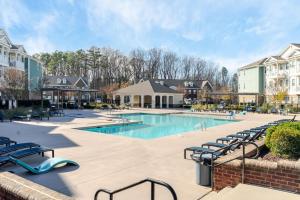 a pool at a resort with chairs and condos at Super Central 1BD Workers Paradise in Charlotte