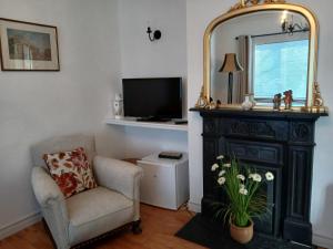 a living room with a mirror and a chair at Conways B&B in Claremorris