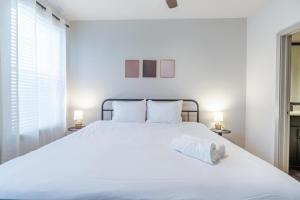 a bedroom with a large white bed with two lamps at Super Central 1BD Workers Paradise in Charlotte +28 photos