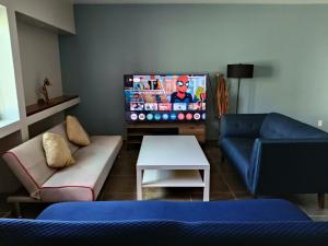a living room with a couch and a flat screen tv at NSI Casa Entera en La Piedad in San Juan del Fuerte