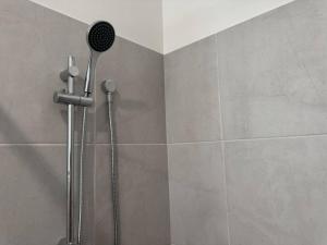 a shower with a shower head in a bathroom at Spacious New Home for 12 Guests in Campbelltown South +25 photos
