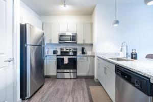a kitchen with white cabinets and stainless steel appliances at Stylish, Comfortable 2BD Abode near DT Matthews in Charlotte +18 photos