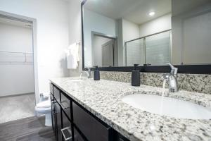 a bathroom with a sink and a large mirror at Stylish, Comfortable 2BD Abode near DT Matthews in Charlotte