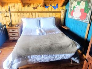 a bed in a room with a wooden wall at Na'raucária in Cambará