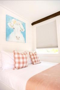 a bedroom with a bed with a cow painting on the wall at NEW! Cozy Container Home at Cliffside #1 in Orderville
