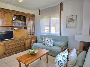 a living room with a blue couch and a coffee table at Apartamento La Hojarada 20809 in Argoños