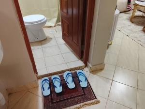 a group of three pairs of blue shoes on the floor of a bathroom at Executive 1bedroom Furnished and BnB apartment with GYM,Swimming pool,Cityview - Kitisuru ,Nairobi in Nairobi +6 photos