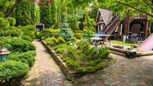 a garden with bushes and trees and a house at Дом на берегу 1dom club in Protsev