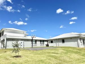 a white building with a basketball hoop in a yard at Spacious New Home for 12 Guests in Campbelltown South